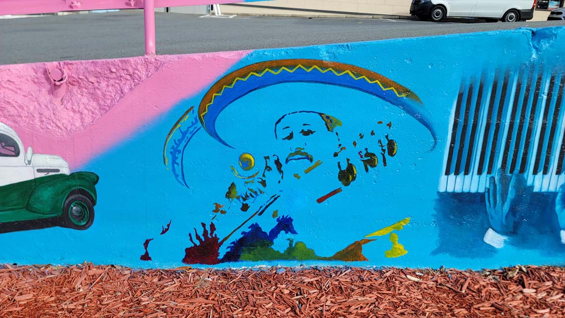 Mural painting of man wearing sombrero and playing guitar